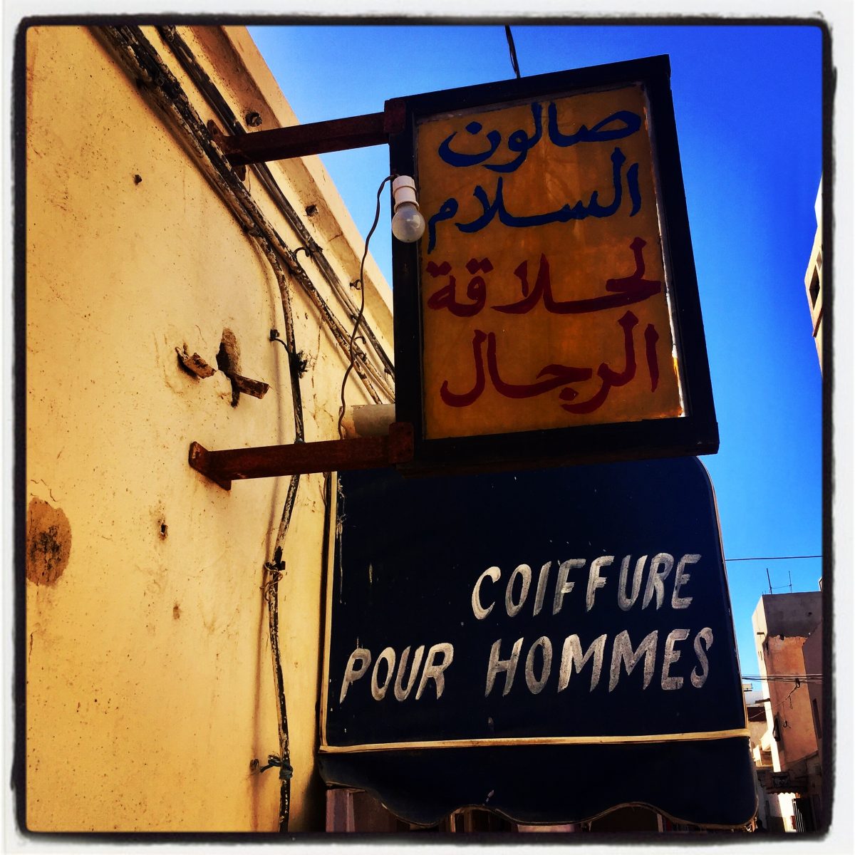 Une enseigne indique coiffure pour hommes en français et arabe #Off2Africa Jour 12 Dakhla Sahara occidental © Gilles Denizot 2016