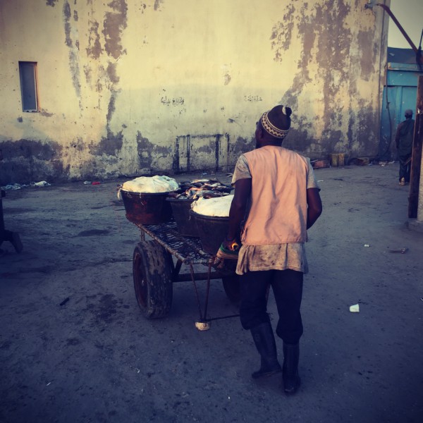 Un homme pousse une charrette et des caisses de poissons #Off2Africa 17 Nouadhibou Nouakchott © Gilles Denizot 2016