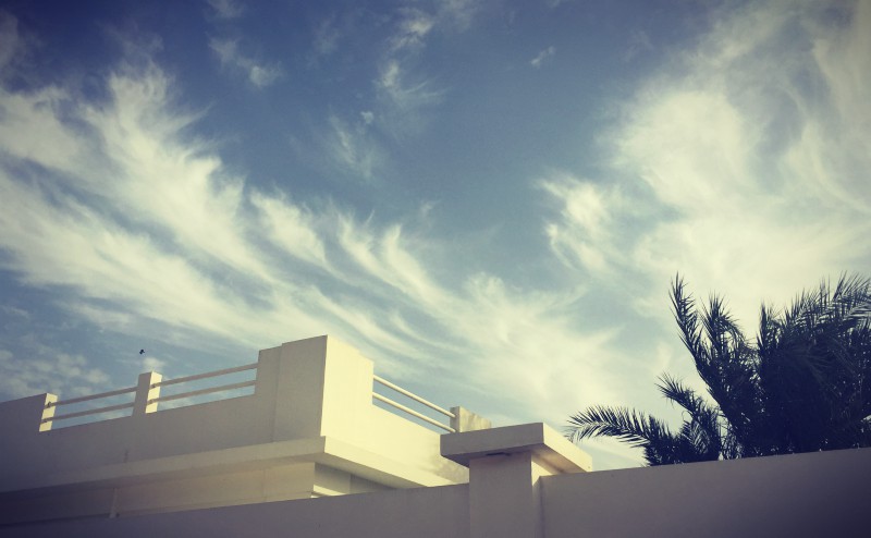 Ciel bleu, quelques nuages, un bâtiment blanc et un palmier qui dépasse #Off2Africa 21 Saint-Louis Sénégal © Gilles Denizot 2016