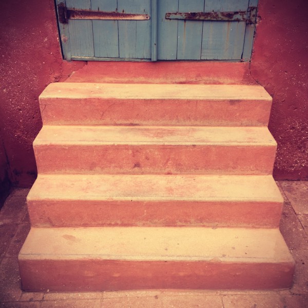Des escaliers jaunes orangés, murs ocres, mènent à une porte bleue #Off2Africa 29 Gorée Sénégal © Gilles Denizot 2016