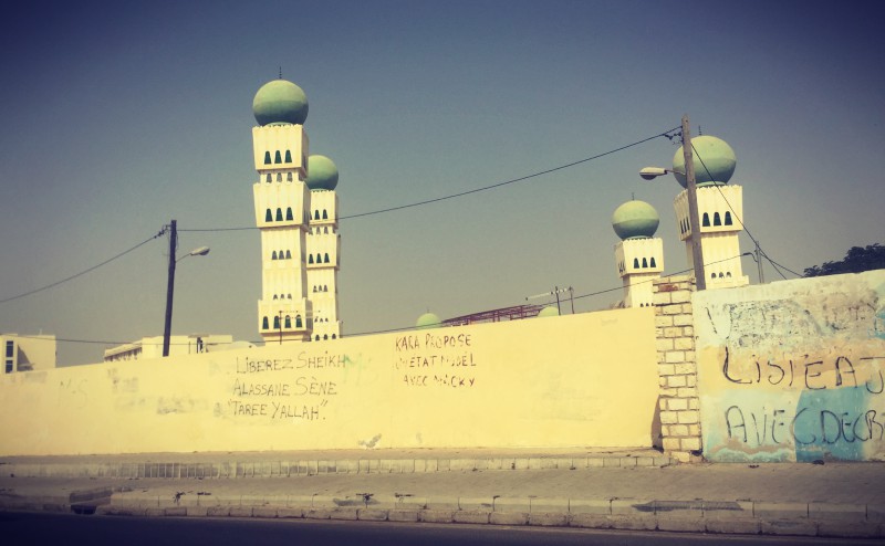 Quatre minarets de mosquée derrière un mur aux graffitis #Off2Africa 35 Dakar Sénégal © Gilles Denizot 2016