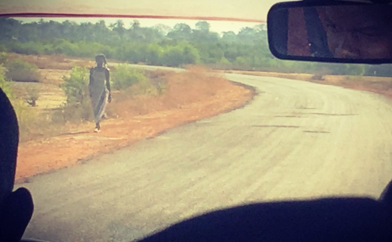 Une femme marche seule sur le bords de la route #Off2África 49 Ziguinchor Bissau © Gilles Denizot 2017