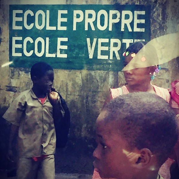 Une inscription ECOLE PROPRE ECOLE VERTE sur un mur, des écoliers devant #Off2Africa 55 Conakry Guinée © Gilles Denizot 2017