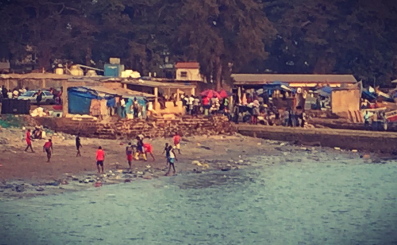 Une foule de gens, certains jouent au football, sur la plage #Off2Africa 58 Conakry Guinée © Gilles Denizot 2017