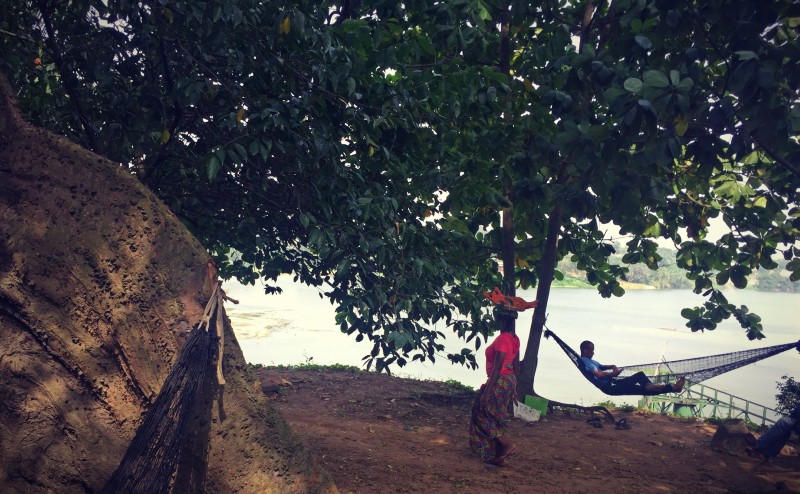 Tranquillité dans un bois, étendu sur un hamac comme un homme en face, une femme qui passe et en bas l'eau des lagunes #Off2Africa 93 Abidjan Côte d'Ivoire © Gilles Denizot 2017