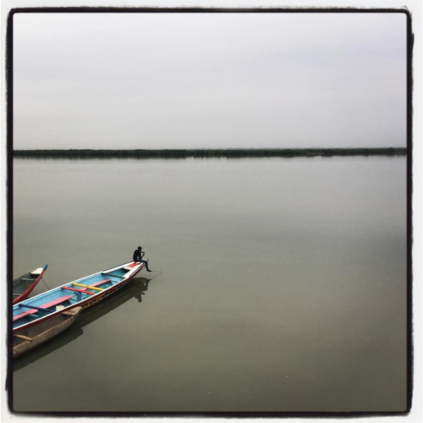 Sur le fleuve Casamance, un homme est assis seul à l'avant d'une pirogue #Off2Africa 46 Ziguinchor Casamance Sénégal © Gilles Denizot 2017