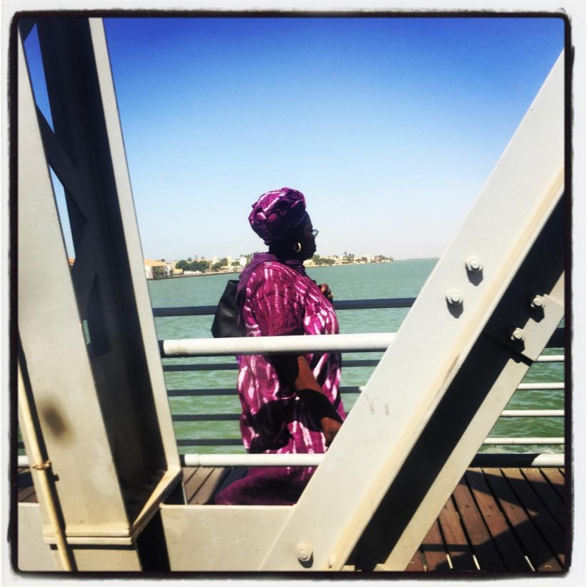 Une femme en boubou rose marche sur le pont Faidherbe en regardant au loin #Off2Africa 20 Saint-Louis Sénégal © Gilles Denizot 2016