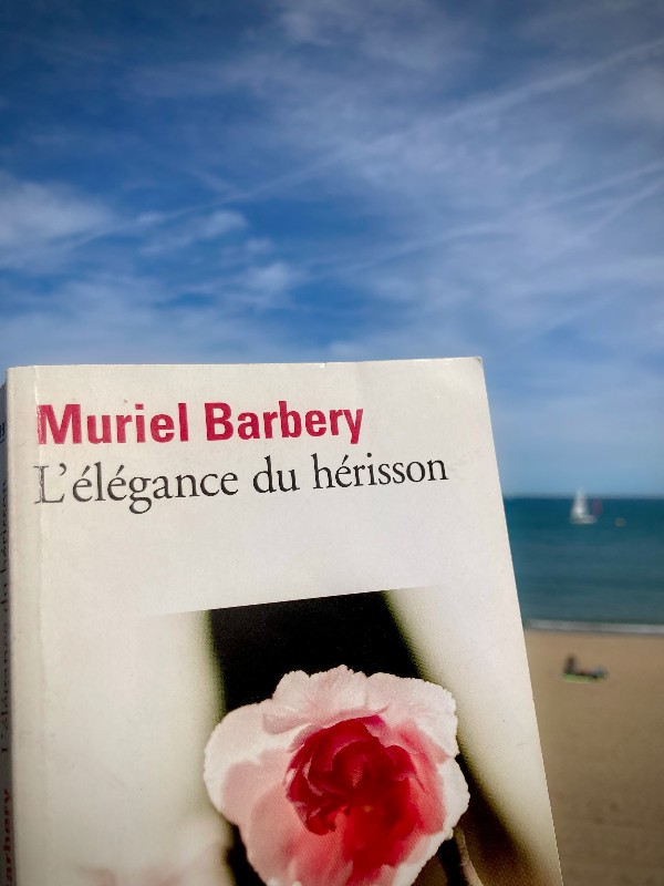 Couverture du livre L'élégance du hérisson, de Muriel Barbery. La vue est celle de la plage à Barcelone, avec un voilier blanc au lointain ©GD24 #HolaBCN Foie maigre